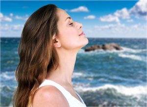 Woman profile portrait breathing deep fresh air on the beach with the ocean in the background Karen Lewis social worker new jersey overcome stress and anxiety